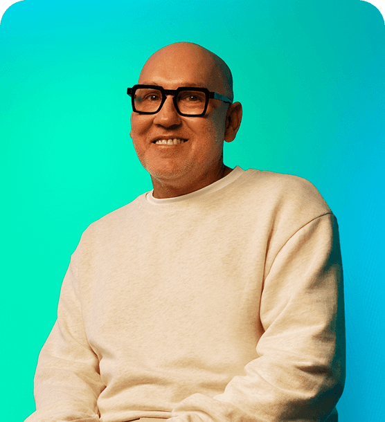 A man with glasses sitting and smiling