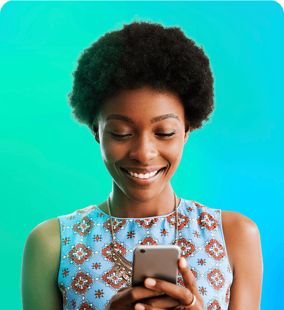 A woman smiling while looking at her phone